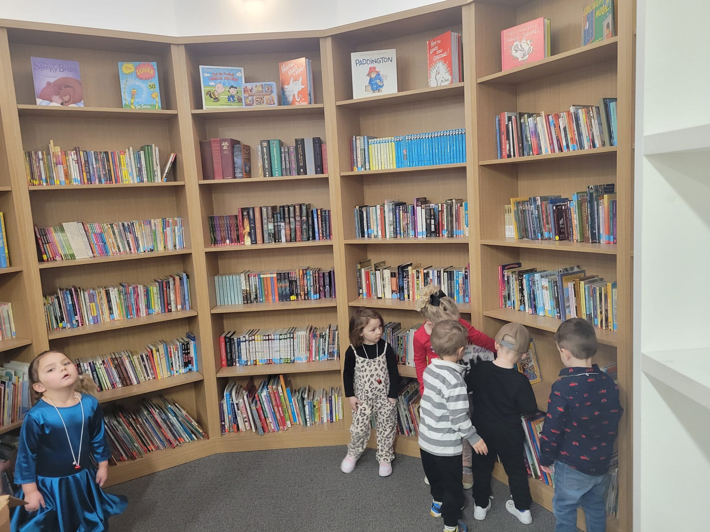 Kindergarteners picking out books in the school's curved library